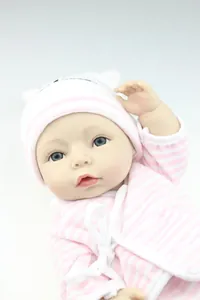 Close-up of lifelike baby doll face with detailed eyelashes and striped knit hat