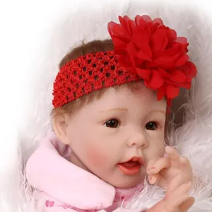 Elastic red crochet baby headband with a large layered mesh flower on a doll