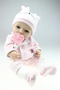 Detailed view of reborn baby doll wearing a pink striped knit hat and matching outfit set