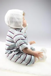 Detailed side view of realistic reborn baby doll in striped outfit with white lace bonnet