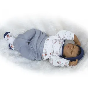 Realistic newborn baby doll with dark skin tone wearing blue outfit on white faux fur