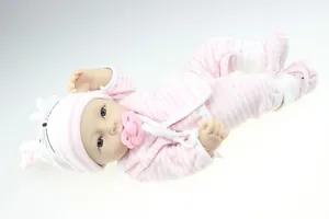 Close-up of lifelike silicone reborn baby doll wearing a pink striped rabbit hat and outfit