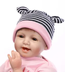 Gros plan d'une poupée reborn réaliste avec un bonnet à oreilles de chat et dents