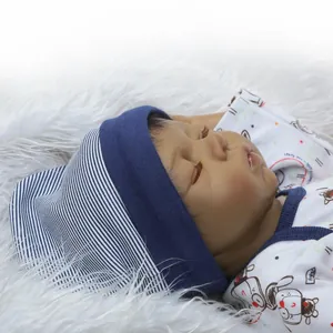 Realistic reborn baby doll with dark skin sleeping in blue and white striped outfit
