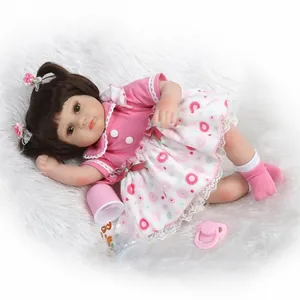 Close-up of realistic baby doll with cherry print dress and pink flower hair clips