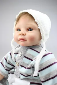 Close-up of lifelike reborn doll with blue eyes, brown hair and knit outfit
