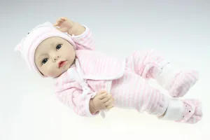 Detailed view of reborn baby doll wearing pink and white striped outfit with matching hat