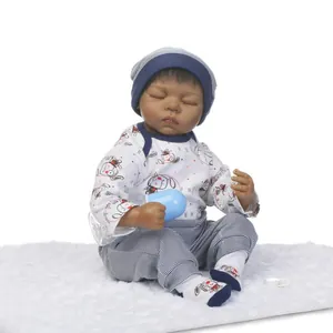 Detailed view of realistic sleeping dark skin newborn doll with blue outfit and bottle