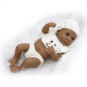 Realistic reborn baby doll with dark skin tone wearing a white knitted outfit