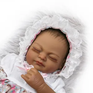 Close-up of sleeping black baby reborn doll with lace bonnet and floral outfit