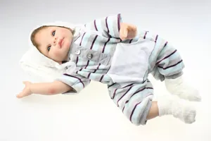 Detailed view of lifelike reborn baby doll in striped romper with knit hat and soft socks