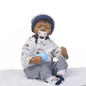 Realistic sleeping African American reborn baby doll in white bodysuit on plush rug