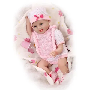 Bambola reborn realistica con completino rosa a pois e biberon su tappeto morbido