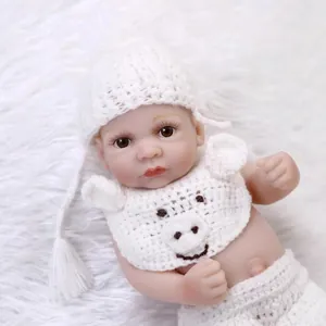 Realistic mini silicone reborn baby doll wearing a white knitted outfit on soft fur