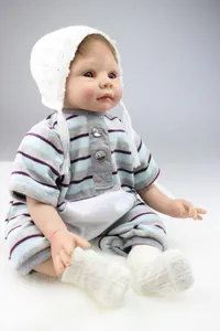 Detail of lifelike silicone baby doll in striped romper and white knitted hat