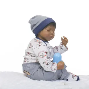 Detail of sleeping black newborn reborn doll in blue striped outfit on plush rug