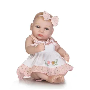 Detail of reborn baby doll featuring lifelike skin texture and floral embroidery dress