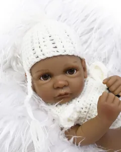 Macro detail of deep skin reborn baby doll with handmade white crochet hat and brown eyes