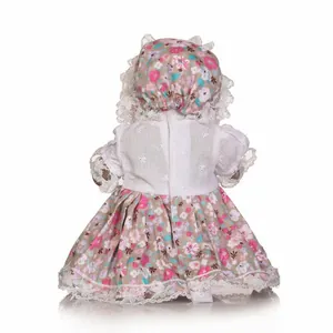 Rear view of mini waterproof doll wearing a floral lace dress and matching bonnet