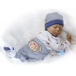 Realistic sleeping reborn baby doll with dark skin tone in blue striped outfit and hat