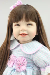Close-up of lifelike girl doll with long brown hair, bow hairband and plaid dress