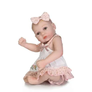 Detailed close-up of realistic mini baby doll featuring pink floral embroidery and polka dot dress