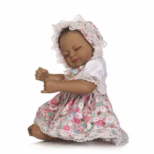 Detailed close-up of a realistic black reborn baby doll in pink floral lace dress