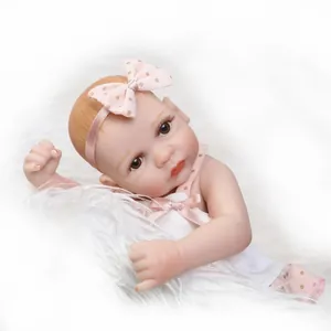 Close-up of lifelike mini baby doll with pink bow headband on soft white faux fur