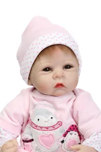 Close-up of lifelike reborn doll face with soft skin details and pink penguin outfit