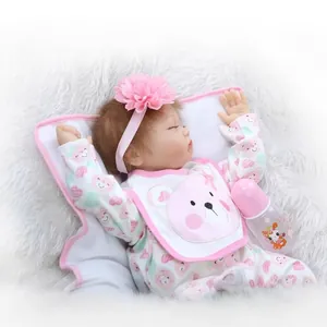 Realistic sleeping reborn baby doll in pink heart outfit with headband and bottle accessory