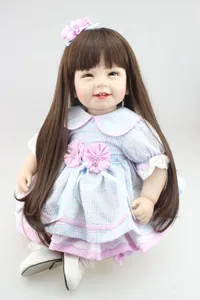 Detail of lifelike baby doll with long brown hair, plaid dress and lace embroidery