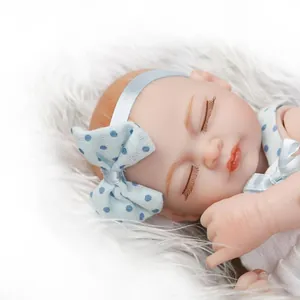 Close-up of a sleeping reborn baby doll with blue polka dot headband on a soft white fur mat