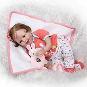 Realistic reborn baby doll with brown hair in red mama's little outfit and plush toy