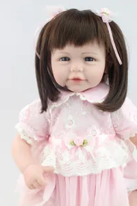 Close-up of 20-inch lifelike doll with brown hair in a pink lace dress and headband