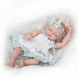 Mini realistic sleeping reborn baby doll in white dress with floral embroidery