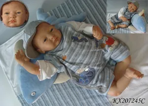 Lifelike reborn baby doll in marine vest and cap resting on a blue dolphin plush pillow