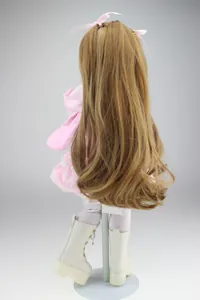 Dettaglio di una bambola snodabile con felpa rosa a orecchie di coniglio e capelli