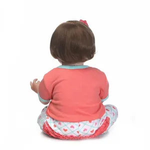 Rear view of a lifelike reborn baby doll featuring dark brown hair and a heart print outfit