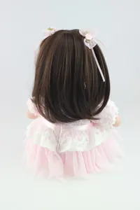 Detail of 20-inch doll back with brown hair, pink lace bows and layered lace dress