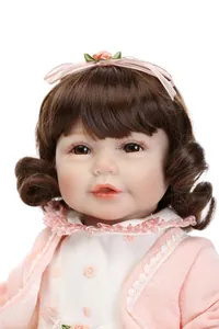 Close-up of realistic baby doll featuring brown curly hair and detailed facial features