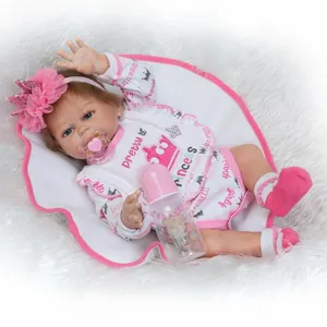 Realistische Reborn-Babypuppe im rosa Kronen-Outfit mit Schnuller und Flasche auf Plüsch