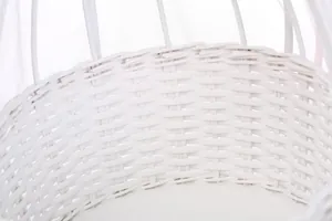 Close-up of white woven wicker baby doll bassinet with detailed texture and padding