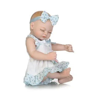 Detailed close-up of a realistic sleeping reborn doll with a blue polka dot headband
