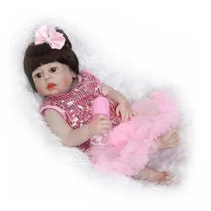 Poupée réaliste bébé reborn en robe de princesse rose sur tapis en fausse fourrure blanche