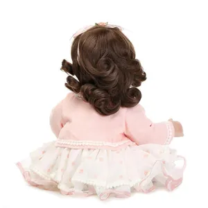 Detail view of doll back featuring thick curly brown hair and pink lace headband