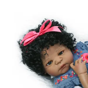 Realistische schwarze Babypuppe mit Locken, rosa Stirnband und floralem Jeanskleid