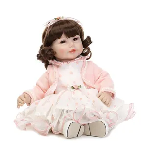 Realistic reborn doll featuring brown curls with pink floral headband and lace dress