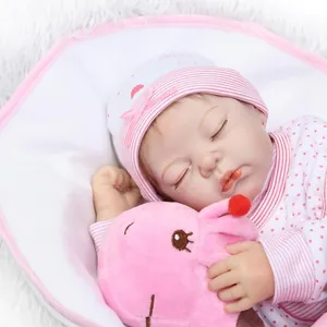 Bambola Reborn realistica con vestito a righe rosa e ippopotamo di peluche su tappeto