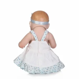 Back view of cute baby doll with light brown hair wearing a white polka dot dress