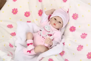 Close-up of a lifelike reborn baby doll in pink overalls with realistic skin details